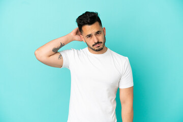 Fototapeta premium Young caucasian man isolated on blue background having doubts