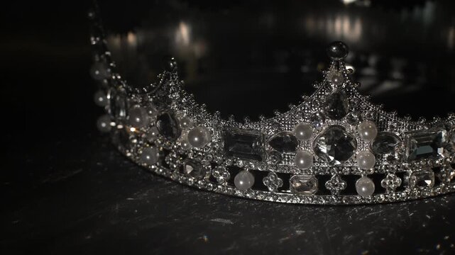 Refined golden crown with gemstones on dark textured background, symbol of luxury and high status. Subtle light reflections create a sense of sophistication, exclusivity and elevated status. 