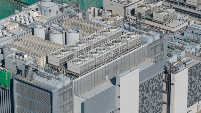 Hong Kong, Hong Kong - 14 February 2026: Aerial view of the industrial rooftop featuring rows of large cooling fans, ventilation units, and storage tanks on a modern building.