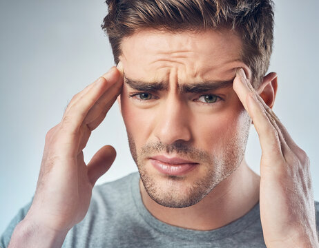 A man in his 20s experiencing headache, emphasizing discomfort around temples and forehead