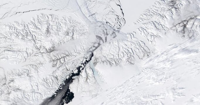 Aerial perspective on  snowy and icy cold land in arctic region. Camera is zooming in. Animation based on image by NASA