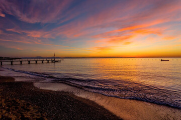 Fototapeta premium Colorful sunset over Mediterranean Sea beach with pier on the Turkish Riviera