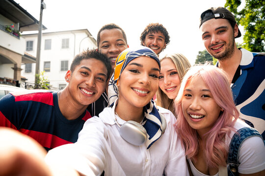 Group of multiethnic teenagers spending time outdoor and having fun