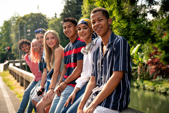 Group of multiethnic teenagers spending time outdoor and having fun
