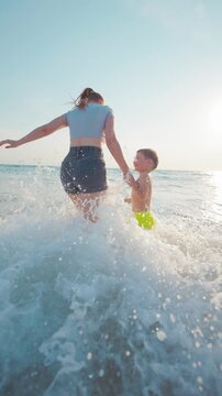 Playing in the waves at the beach on a sunny day with a child running in the water
