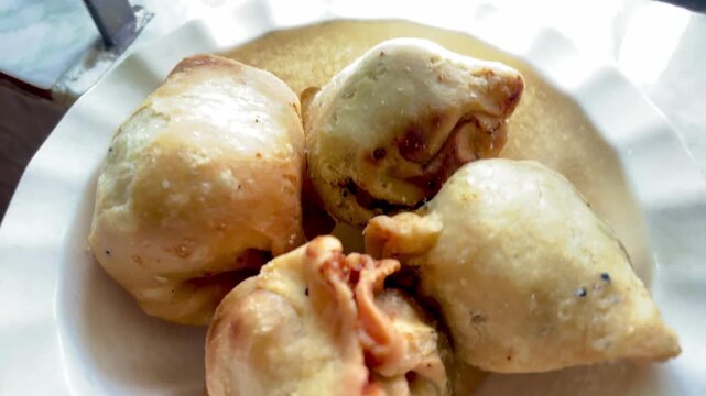 Freshly fried singara (shingara), a crispy triangular Bangladeshi snack filled with spiced potatoes, cauliflower, and peanuts. A popular street food in Bangladesh and India.