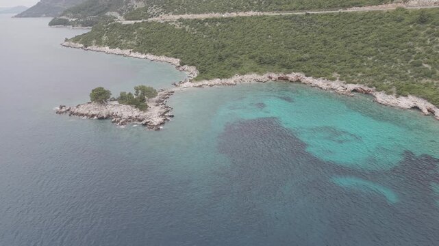 Small Rocky Island with Pine Trees in Turquoise Sea