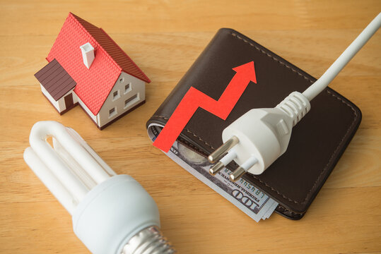 House, light bulb, electrical plug and wallet with growth red graph on table. Electricity prices increase, energy crisis in war, home financial management and planning, expense control concept.
