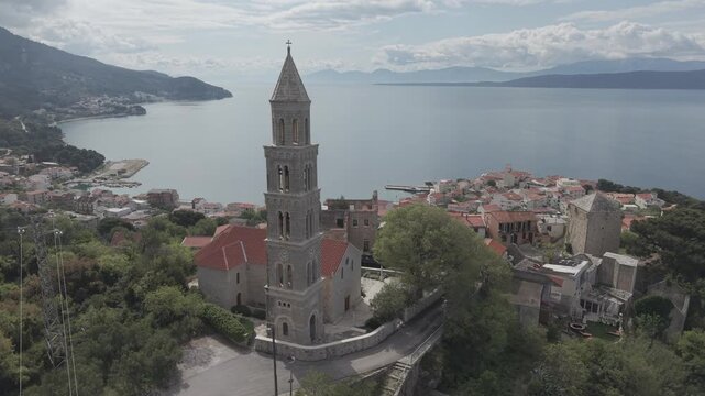Aerial View of Coastal Village with Church Tower and Mountain Bay