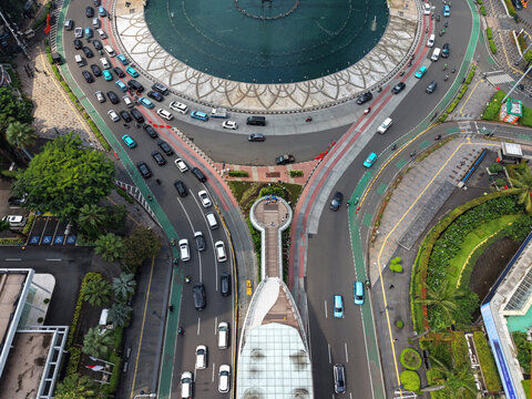 Menteng, Indonesia - 02 April 2026: Aerial view of Bundaran HI roundabout featuring heavy traffic flow, modern urban infrastructure, and lush surrounding greenery.