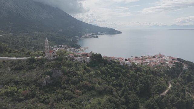 Aerial View of Coastal Village with Church Tower and Mountain Bay