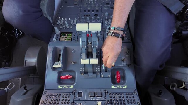 closeup view of the hand of a caucasian pilot (Captain seat), deploying the speed brakes to reduce speed in a real time flight, captured in a modern jet cockpit. 4k top view shot.