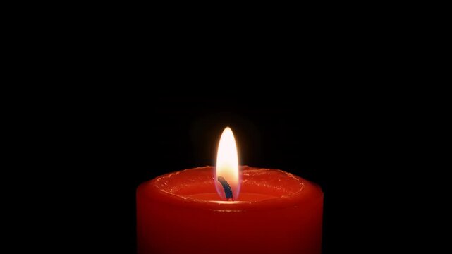 Red candle, flame and burning in dark background for hope, mourning and Christmas celebration. Fire, light and wax with glow, flickering and heat in peace for prayer, memorial and spiritual soul