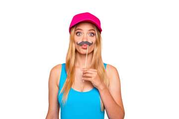 Young attractive nice foolish straight-haired blonde girl, grimacing showing like fake mustache, plump pouted lips. Bright pink cap. Isolated over beige background © deagreez