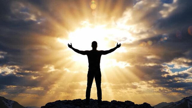 A silhouette of a person standing on a rocky outcrop, arms spread wide against a dramatic backdrop of clouds and radiant sunlight, symbolizing freedom and triumph.