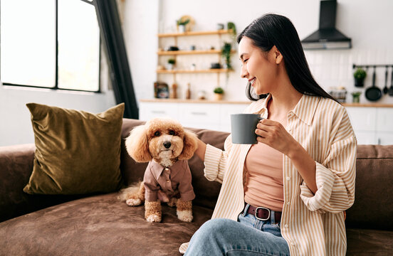 Woman with dog enjoying coffee at home.