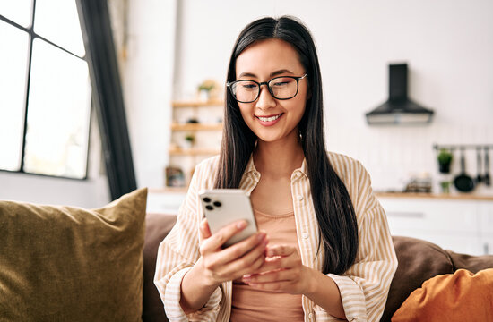 Young woman using smartphone at home.