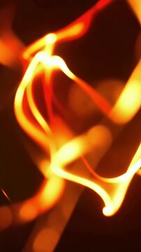 Extreme close-up of blazing fire flames, vertical video featuring intense burning textures, glowing embers and dramatic cinematic fire effects