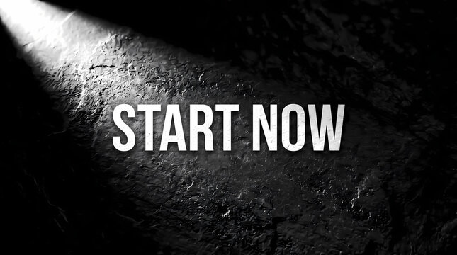 Bright white bold text reading start now centered on a dark textured background illuminated by a sharp beam of light coming from the upper left corner in this conceptual image.