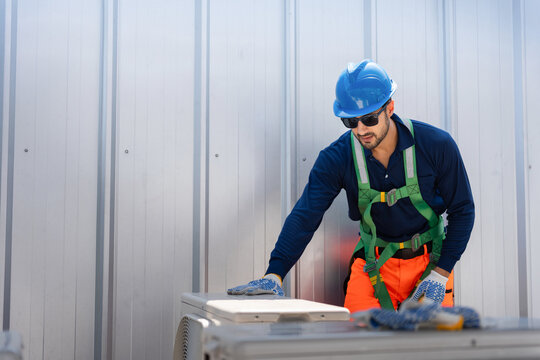 Professional HVAC technician inspecting air conditioning unit on building roof, Industrial worker repairing cooling system equipment, Technician performing maintenance on outdoor hvac condensing unit