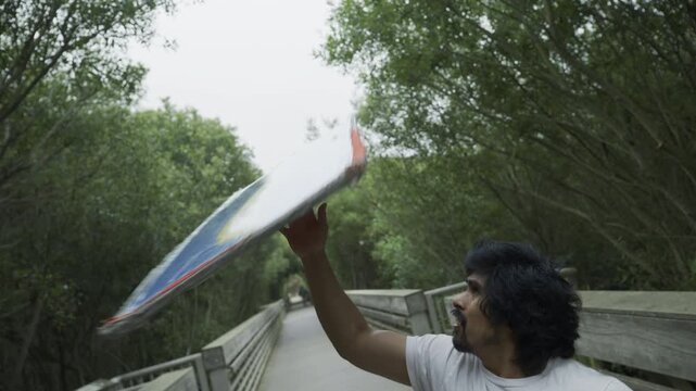 Happy Man Doing Fun Trick With Painted Board - Slow Motion Medium Shot