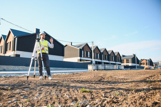 Surveyor using total station at new construction site