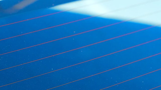 A sticker with the universal wheelchair symbol is glued to the rear window of a white car.