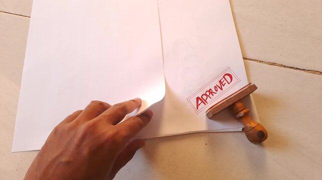 Red rubber stamp APPROVED on torn white paper with data background. Business document, contract, agreement. 4K video for paper background, white background, stamp, torn paper, data, business, office
