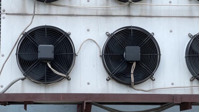 Rotating cooling and ventilation systems on the wall of a data center warehouse building, showcasing modern infrastructure