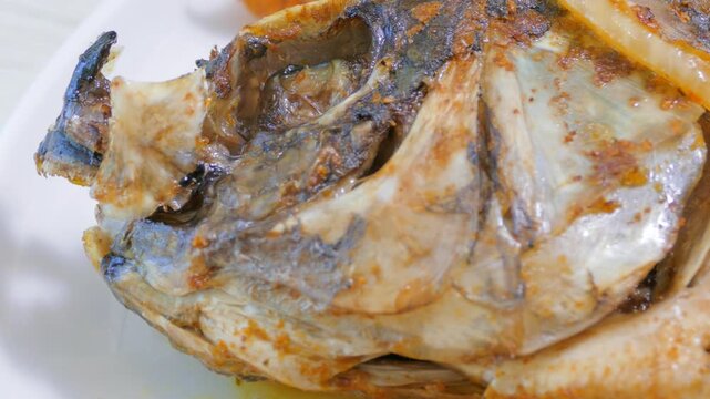 Macro detail of fried whole fish head with savory spices