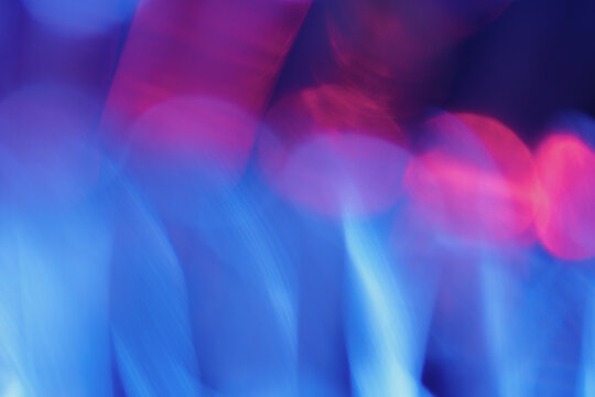 Vibrant abstract background with blurry blue petals and bright pink bokeh orbs. A bold neon color contrast creates a dynamic and modern floral texture for creative design overlays.
