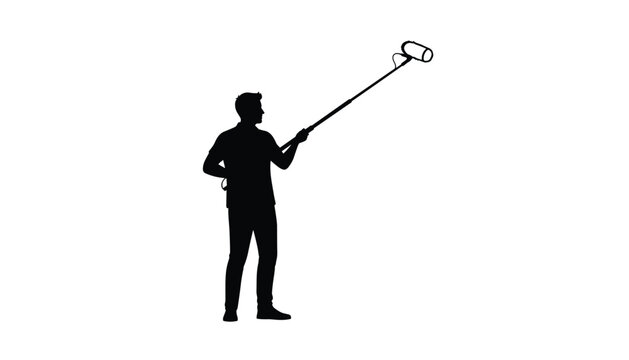 Sound technician holding a boom microphone pole to capture audio during a professional video production or film shooting project on set.