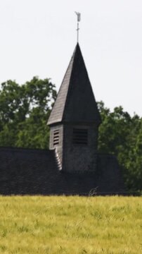 Old wooden church steeple in a rural wheat field