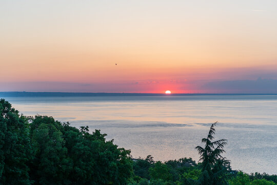 Half-Risen Sun Above the Sea with Clouds and Bird Silhouette