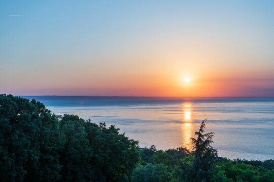 Cool Morning Sunrise over the Sea with Forest Silhouette