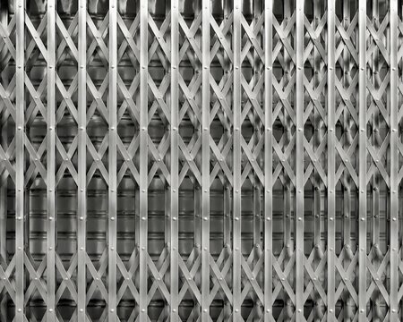 Overlapping metallic silver patterns of two sliding security gates creating hypnotic optical moire wave effect