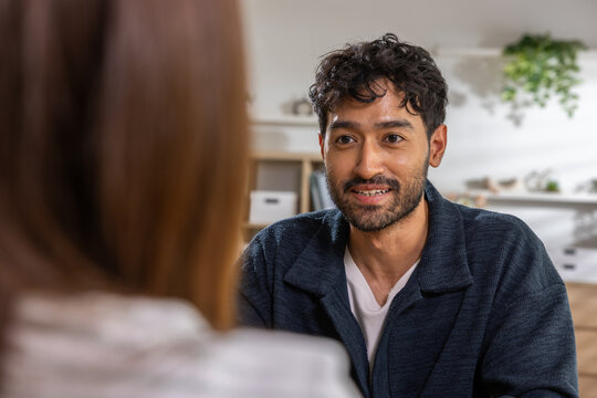 Man woman conversation smile home indoor adult couple close conversation at home with smiling man, casual setting, soft light, blurred woman foreground, relaxed lifestyle moment