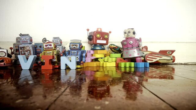 Vintage robot toys make the word VINTAGE with wooden letters in stop motion.
