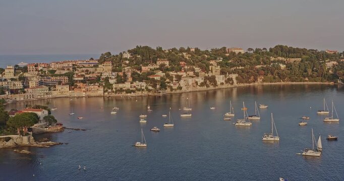 Villefranche sur Mer France Aerial v6 establishing drone fly around luxury hillside neighborhoods with yachts mooring and anchoring on mediterranean sea in the foreground - July 2021