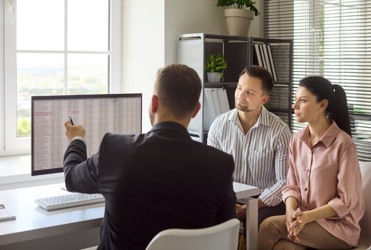 Couple clients meet realtor agent for property. They review mortgage options on a computer and discuss contract details and timeline for purchase. Clear concept of real estate consultation.
