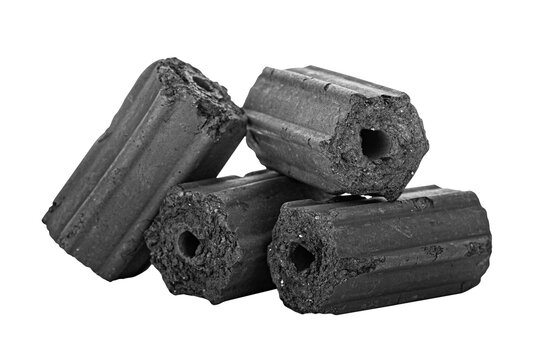 Black charcoal briquettes are arranged on a white background with clipping path