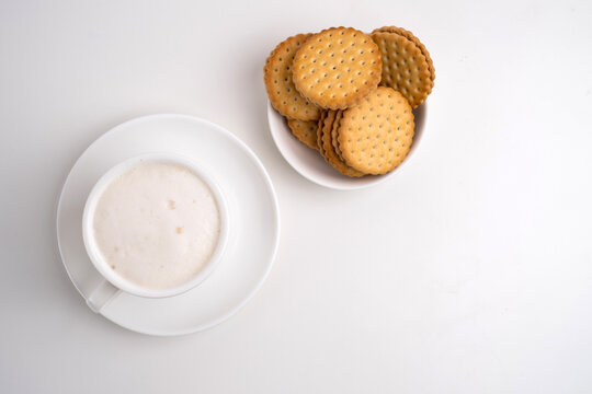 Top view of a cup of frothy coffee and sandwich cookies