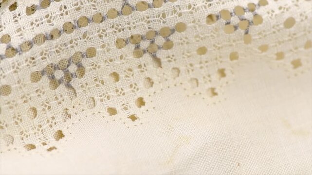 Cross stitch on linen fabric, handmade cross-stitch texture background, lace, natural eco folded linen tablecloth. Bio textile material backdrop, canvas top view, close up, rotating 