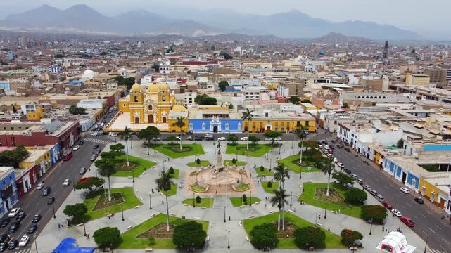Aerial view of the historic Plaza de Armas in Trujillo, featuring the iconic yellow cathedral, lush gardens, and colonial architecture in Trujillo, La Libertad, Peru.