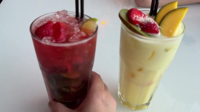wo glasses of mango and strawberry smoothies are placed on a wooden cutting board. mango and strawberry smoothies, healthy juice, healthy drinks, healthy drink menu