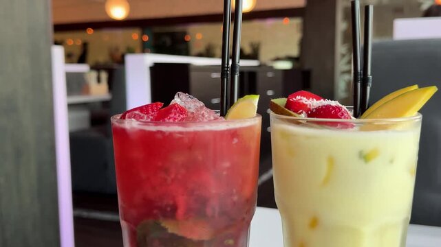 wo glasses of mango and strawberry smoothies are placed on a wooden cutting board. mango and strawberry smoothies, healthy juice, healthy drinks, healthy drink menu