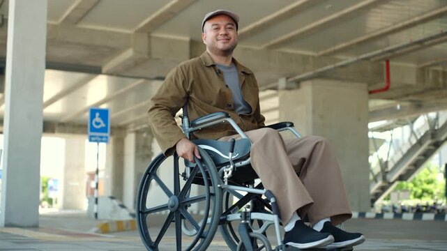 Happy disabled man using a wheelchair independently on accessible city sidewalk with barrier-free infrastructure. Equal access. Smart city, disability rights. Independent mobility.
