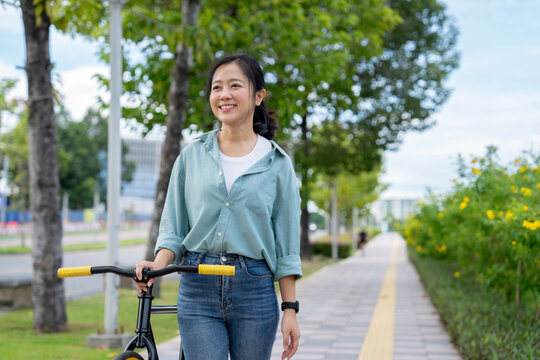 Asian businesswomen ride bicycles in big cities.