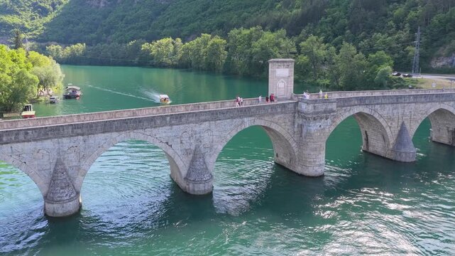 Visegrad, Bosnia and Herzegovina &ndash; May 30, 2026: Close drone view of stone arches and reflections on the Drina River at Mehmed Pasha Sokolovic Bridge