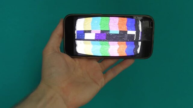 Male Hand Holding Portable Device with Glitch TV Signal Animation